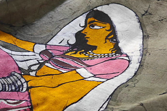 Colorful depiction of a woman with black hair and a pink dress on a Handloom Saree done in Batik style.