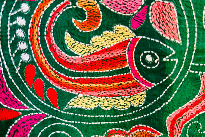 Close-up of colorful Kantha embroidery with fish design on a green saree