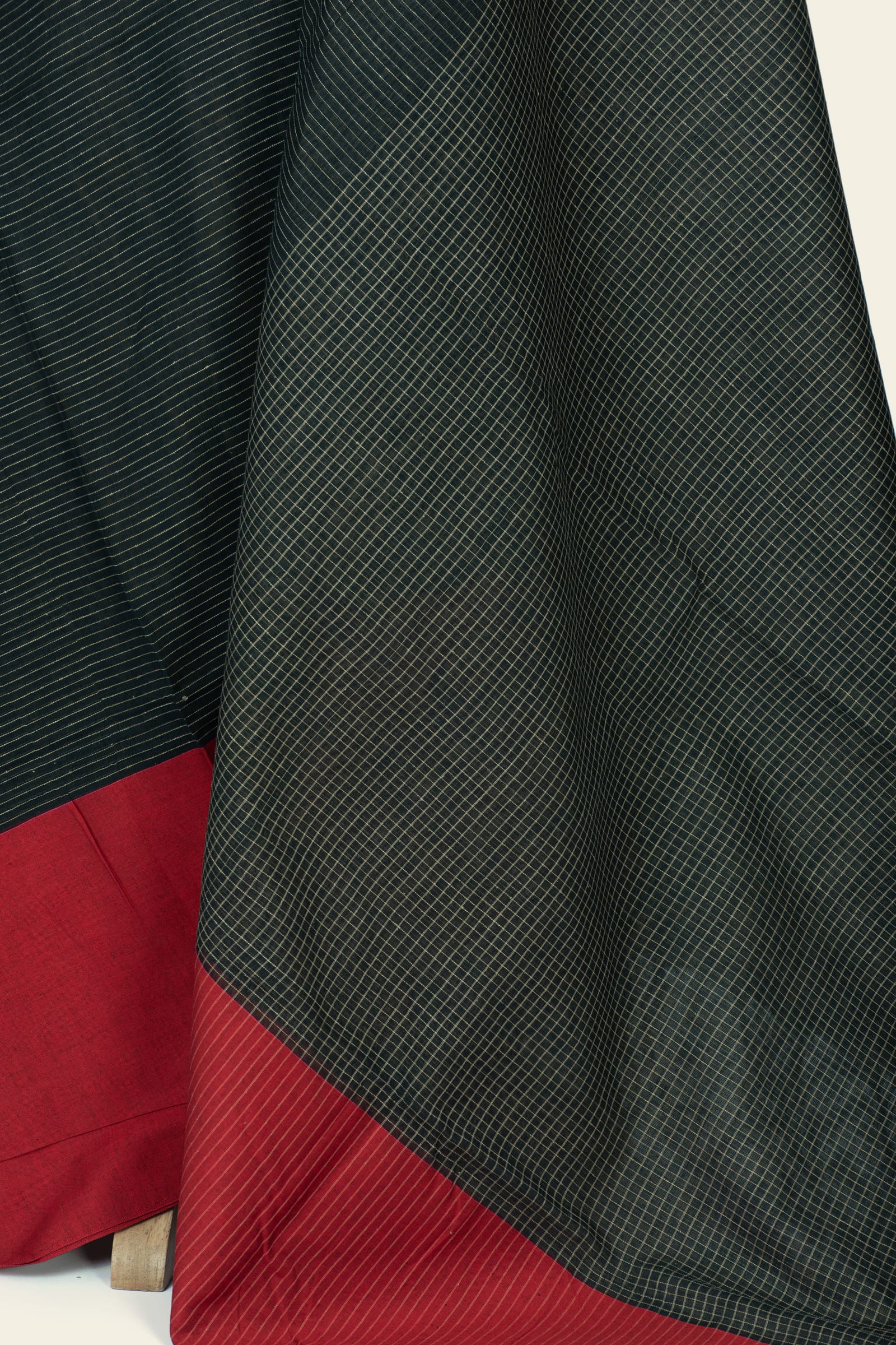 Close-up of saree fabric showing a dense small diamond grid on the pallu and red striped border at the edge.