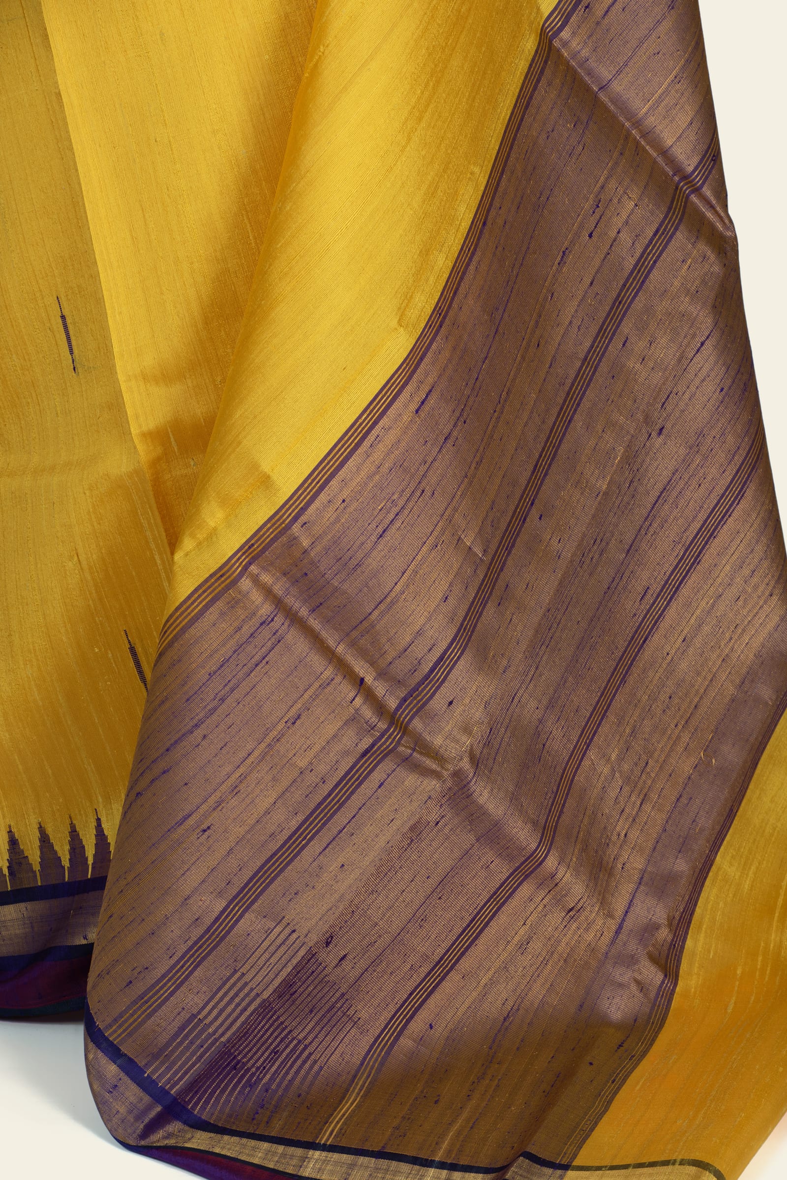 Close-up of the pallu showing woven horizontal stripes in purple and a gold-tinged ground with visible irregular slubs.