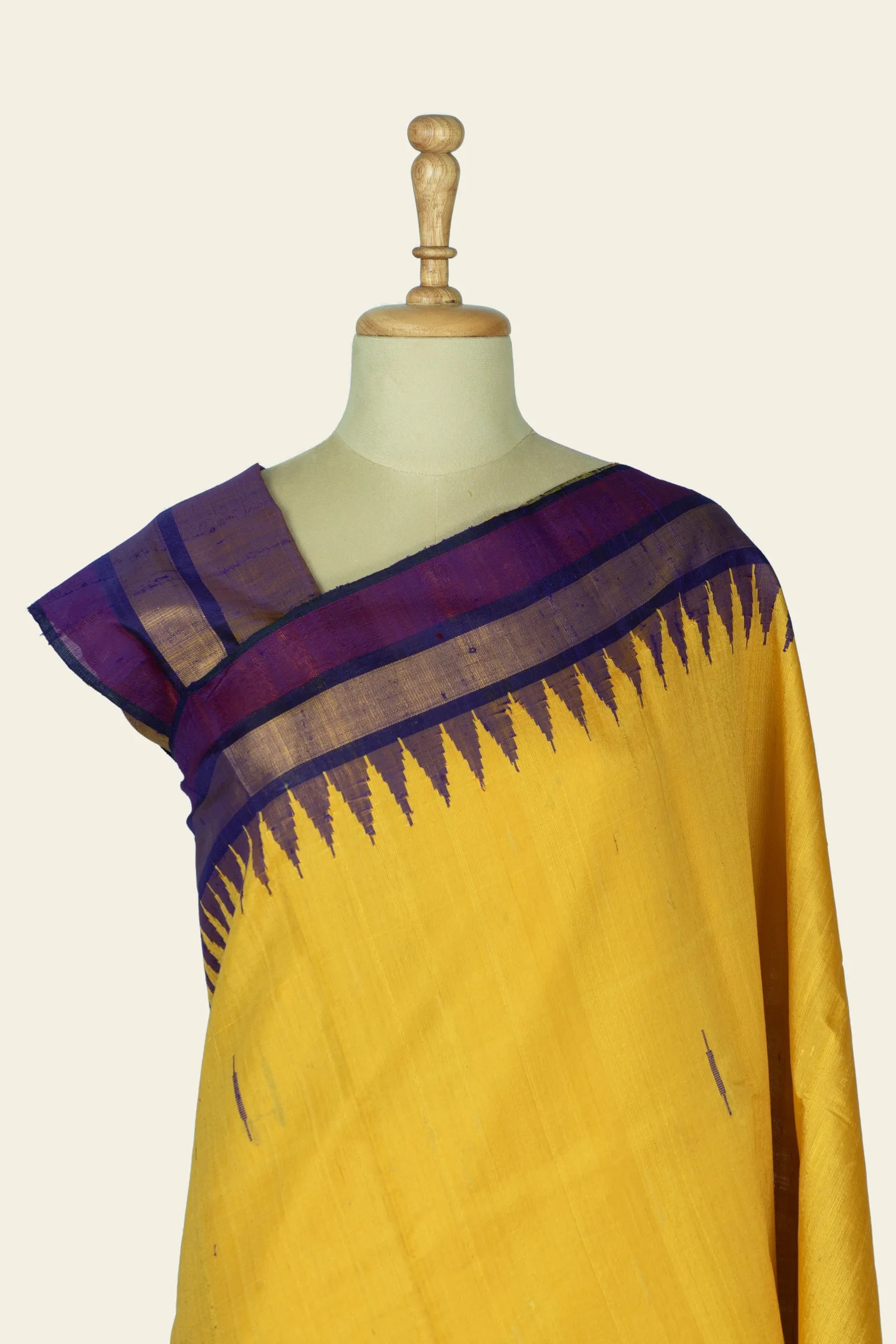 Close front view of the upper saree and blouse area showing the purple border bands and repeated triangular motif near the shoulder.