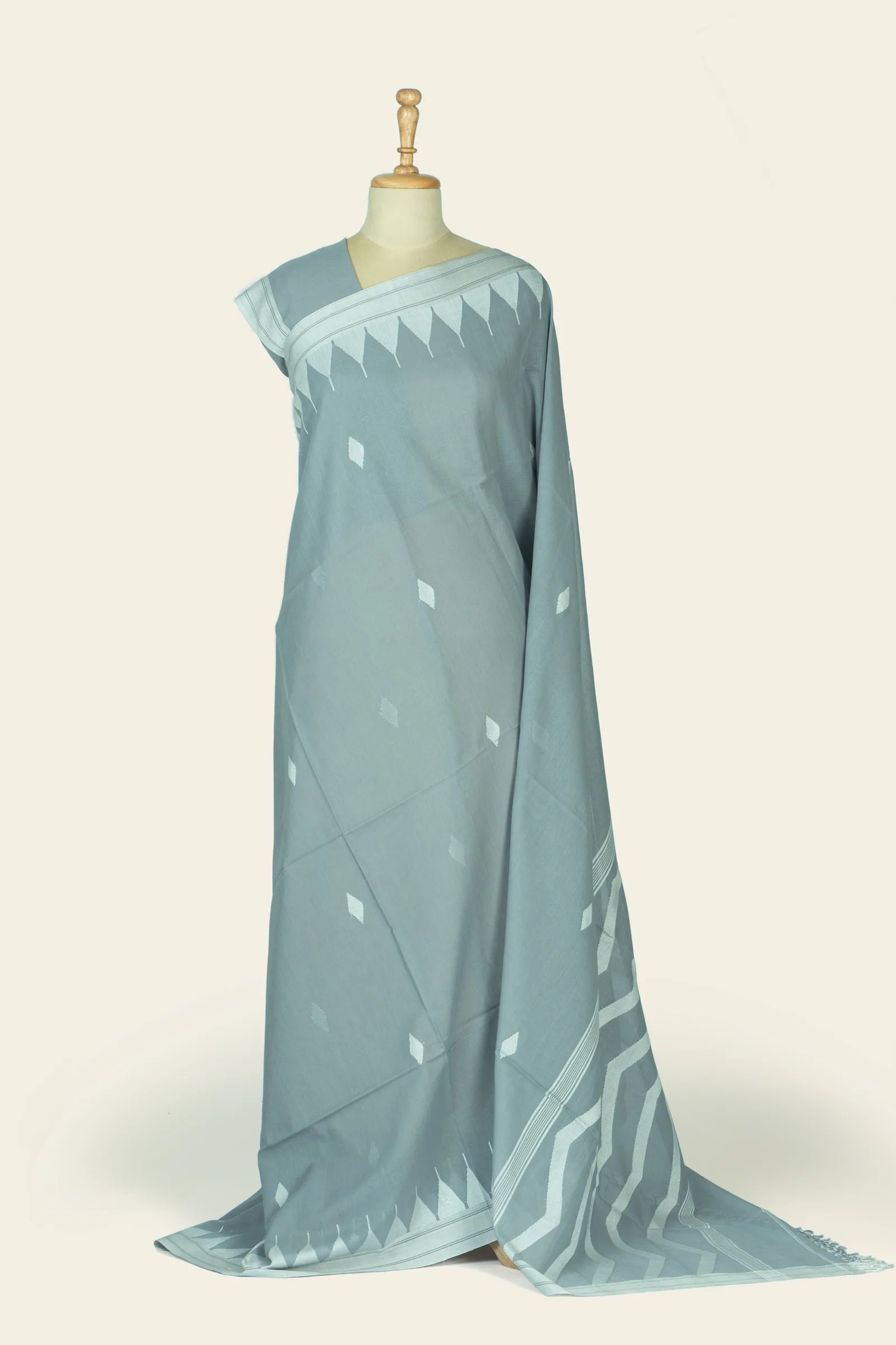 Full-length drape showing the saree body with scattered diamond butis and a triangular border near the shoulder, plus the zigzag pallu pooled at the base.