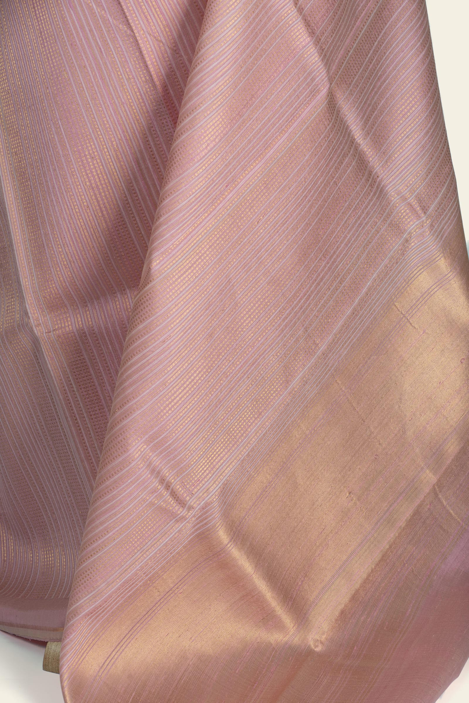 Close-up of the fabric showing diagonal stripe weave and a broad gold-toned border area.