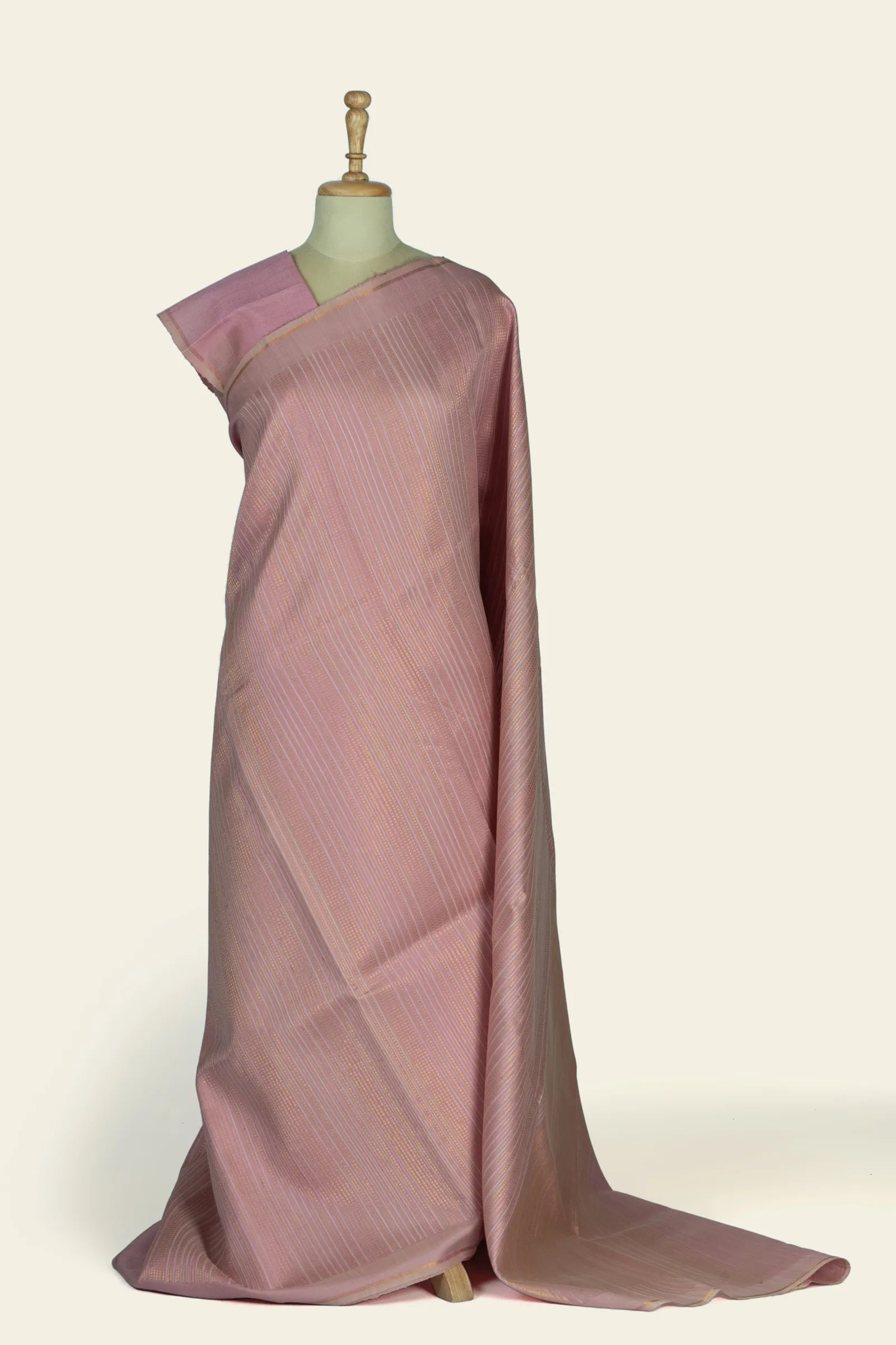 Full-length drape of a dusty pink saree on a mannequin showing vertical striped body and gold-toned border.