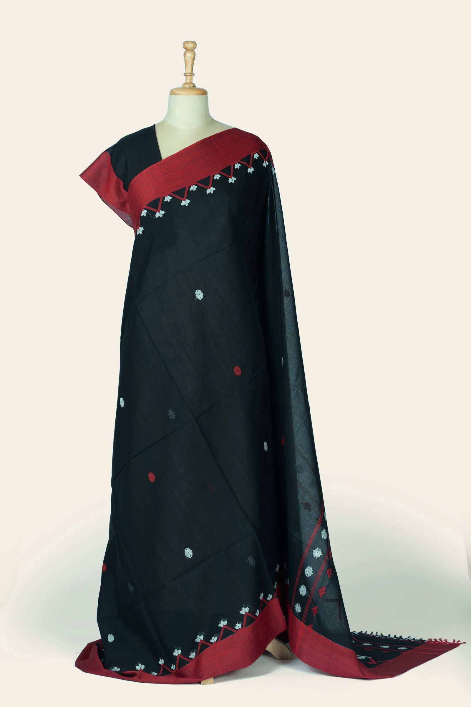 Full-length front view of a black saree draped on a mannequin showing scattered small flower buta and a maroon border with triangular motif band.