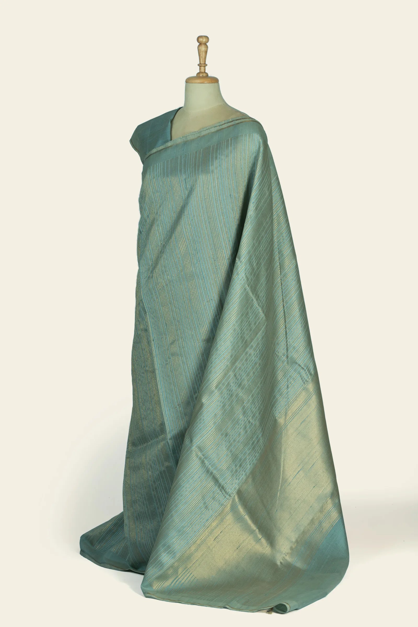 Side-angle view of the saree draped on a mannequin showing the gold-sheened pallu and striped body.