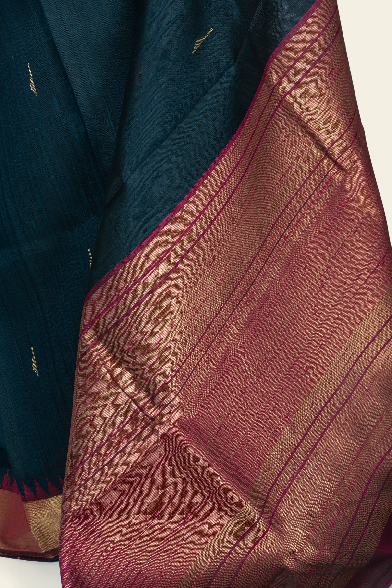 Detailed shot of the pallu showing fine horizontal gold zari lines on a maroon ground and the contrast with the indigo body.
