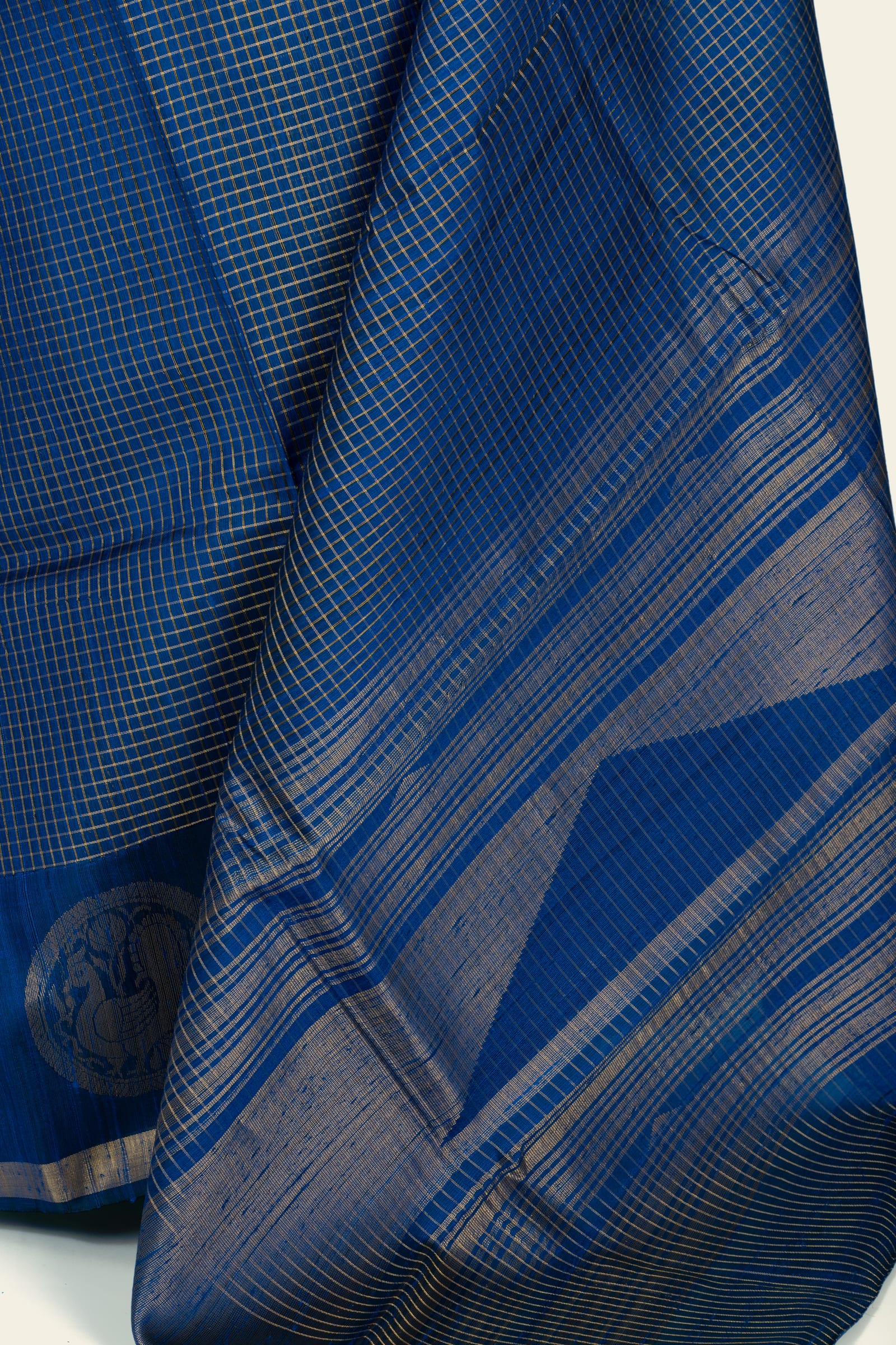 Close-up of the saree pallu and body showing the fine check weave and closely spaced horizontal gold stripes on the pallu.