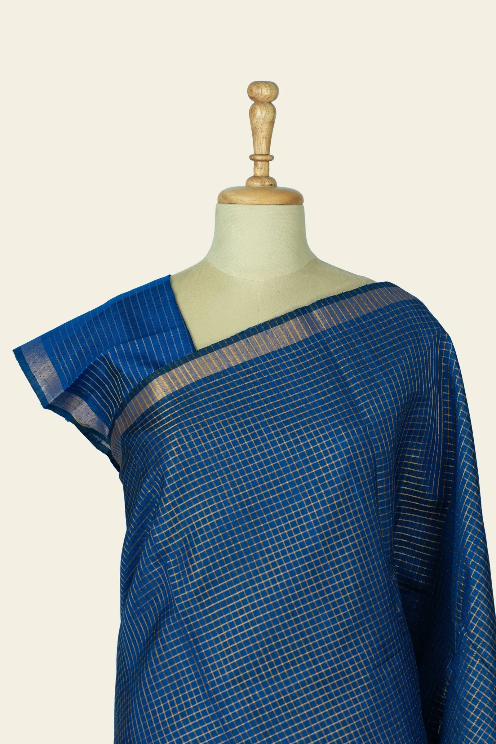 Close front shot of the upper saree and blouse area showing the checked pattern and narrow gold border along the shoulder.