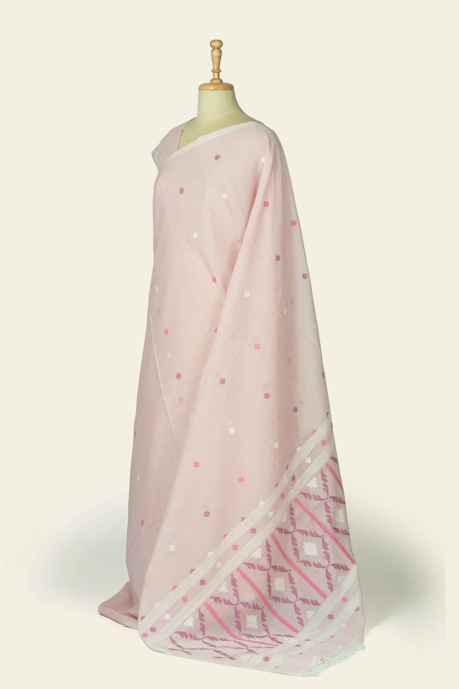 Side view of the saree draped on a mannequin, showing the body motifs and the patterned border near the hem.