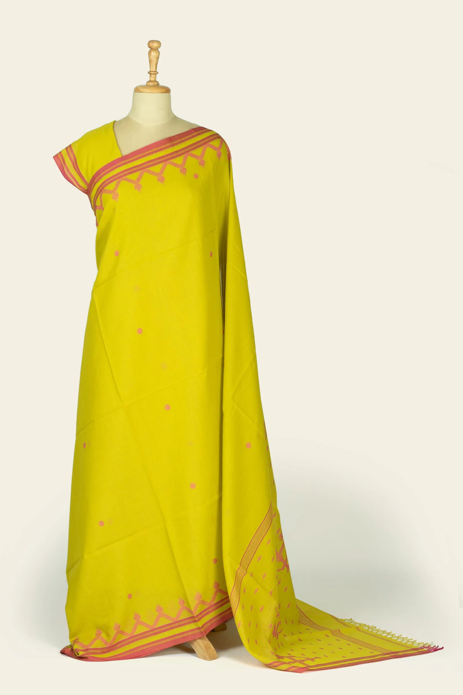 Full-length front drape of a lime green saree shown on a mannequin, with scattered small pink dots and a pink striped border near the shoulder and hem.