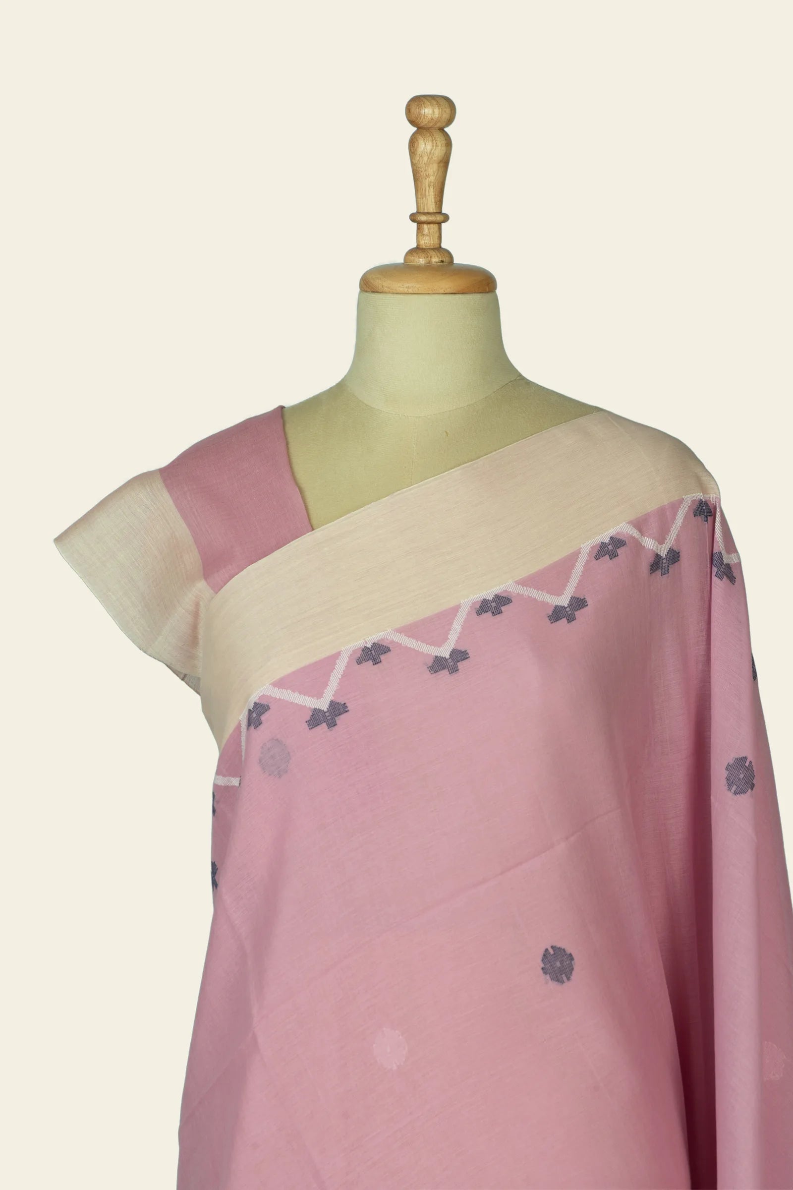 Close front view of the upper saree on the mannequin highlighting the cream shoulder border and small woven floral motifs near the chest.