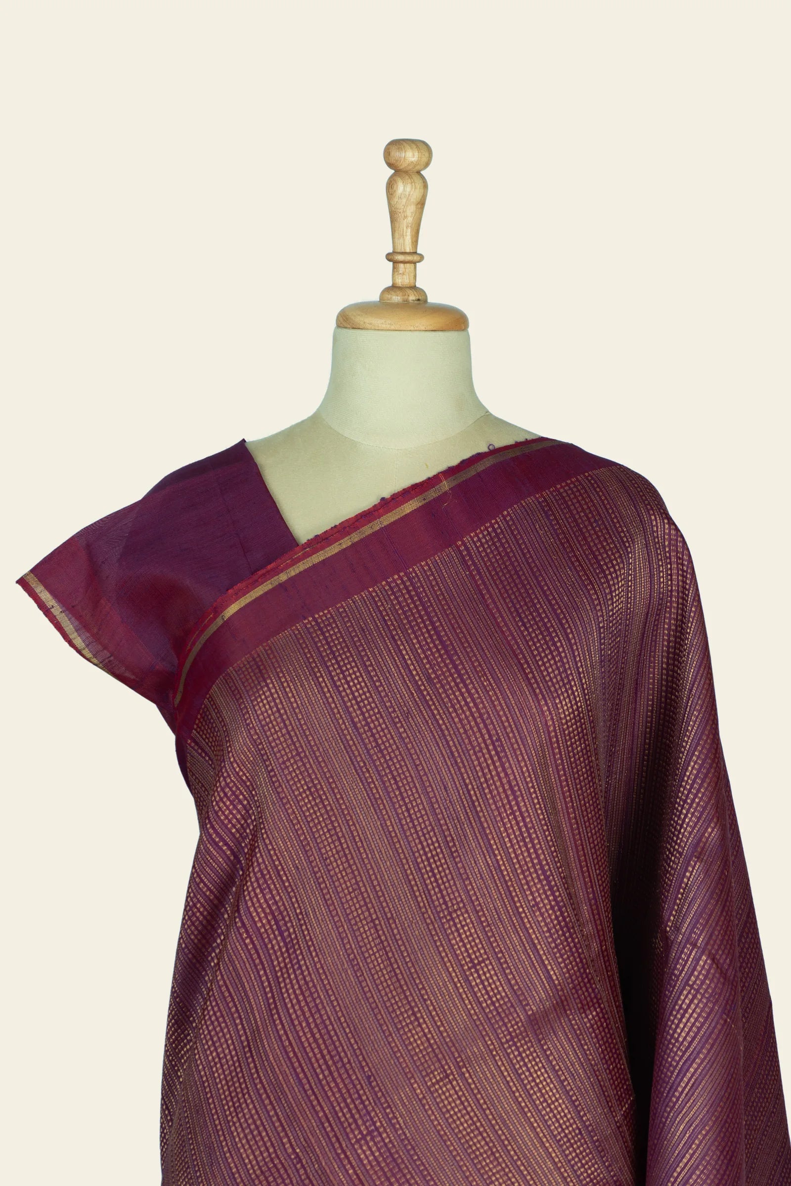 Close view of the upper drape and blouse area highlighting the fine stripe pattern and a narrow gold border along the shoulder.