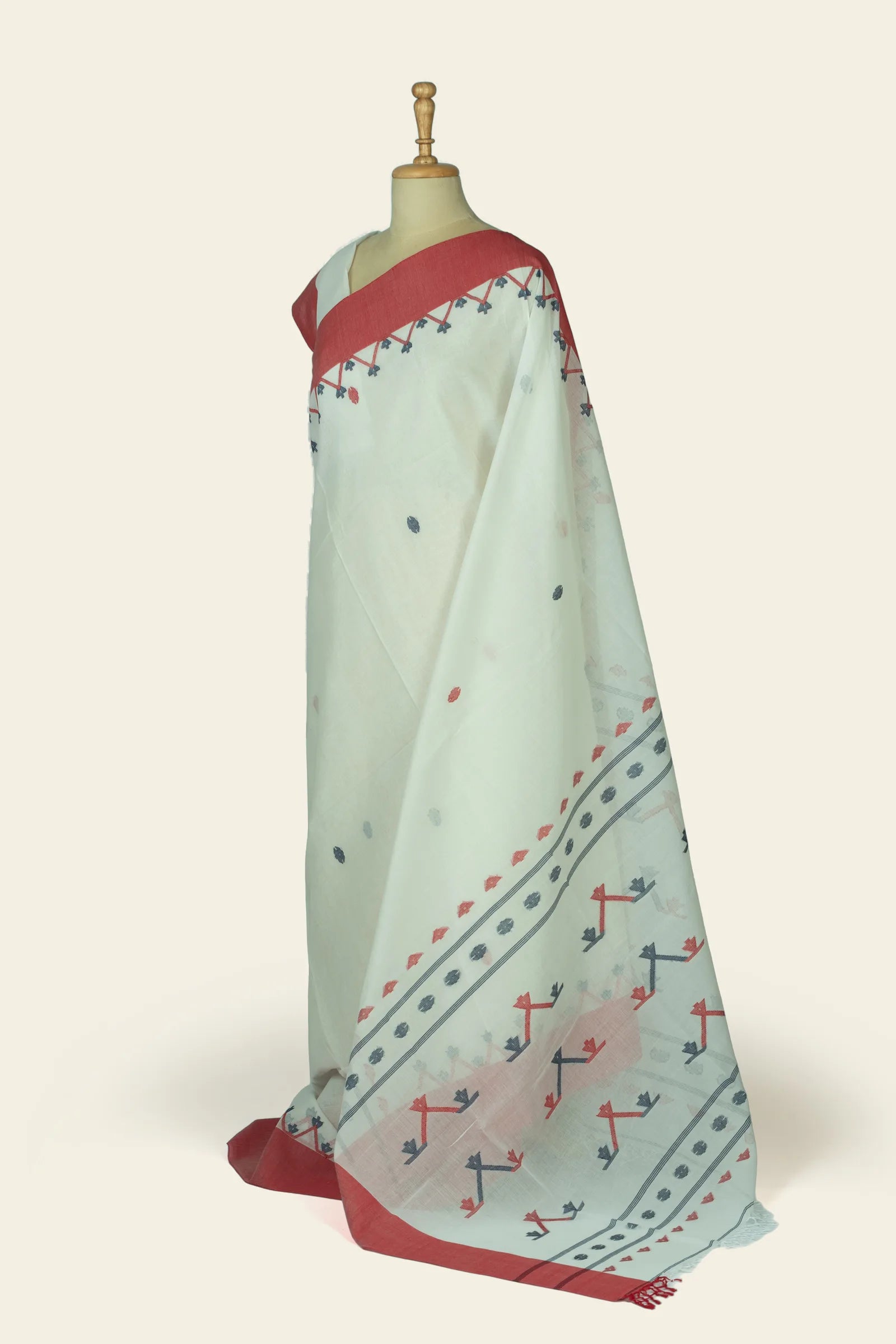 Side view showing the saree drape and the patterned pallu with geometric motifs and double stripe near the edge.