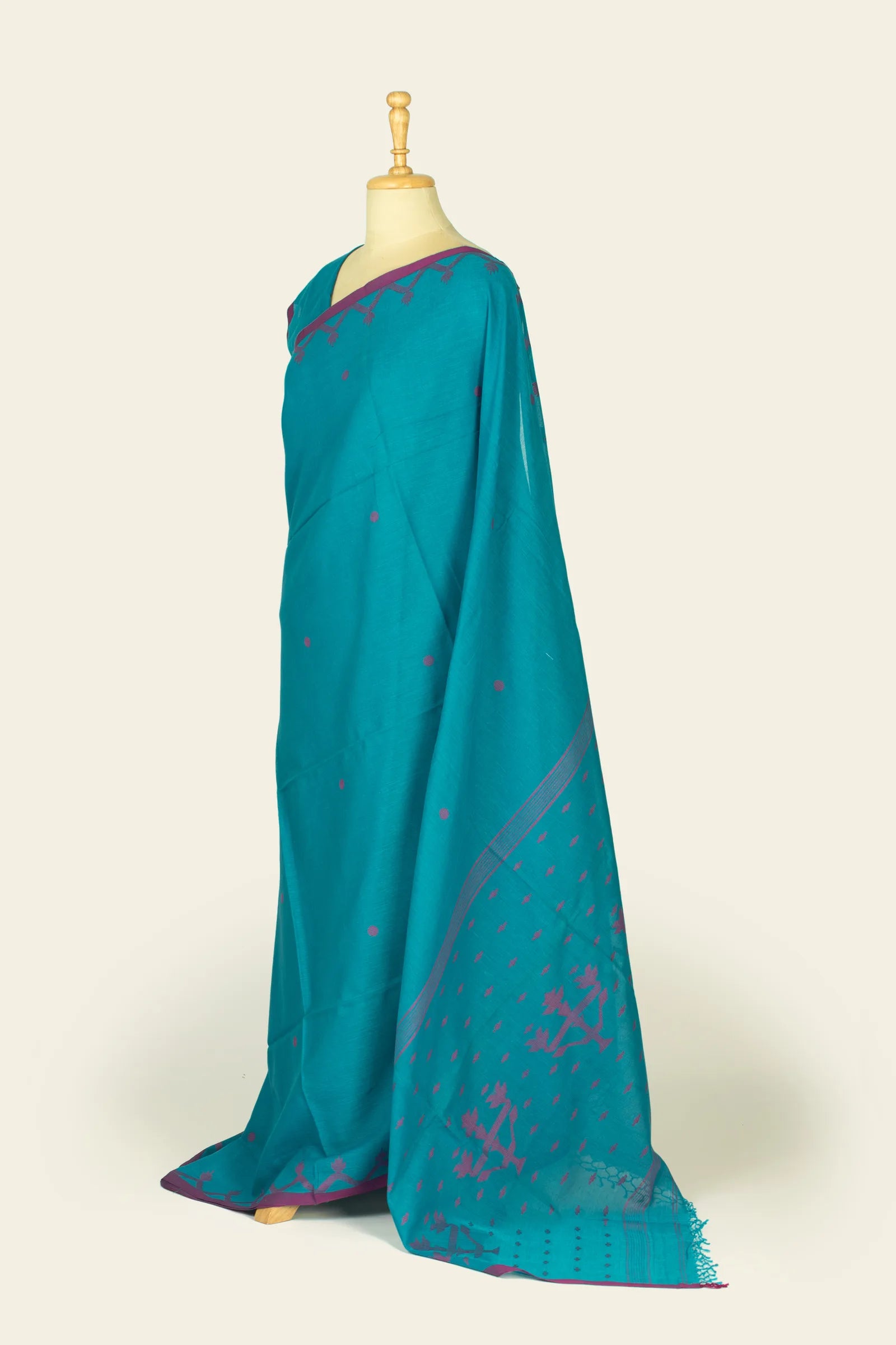 Side view of the saree showing the pallu drape and magenta woven motifs near the hem.