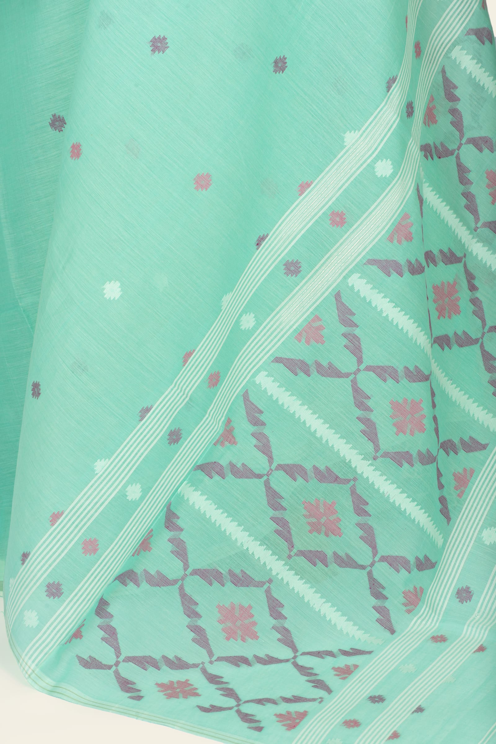 Close-up of saree's border and pallu showing woven geometric motifs and small buta near the edge.