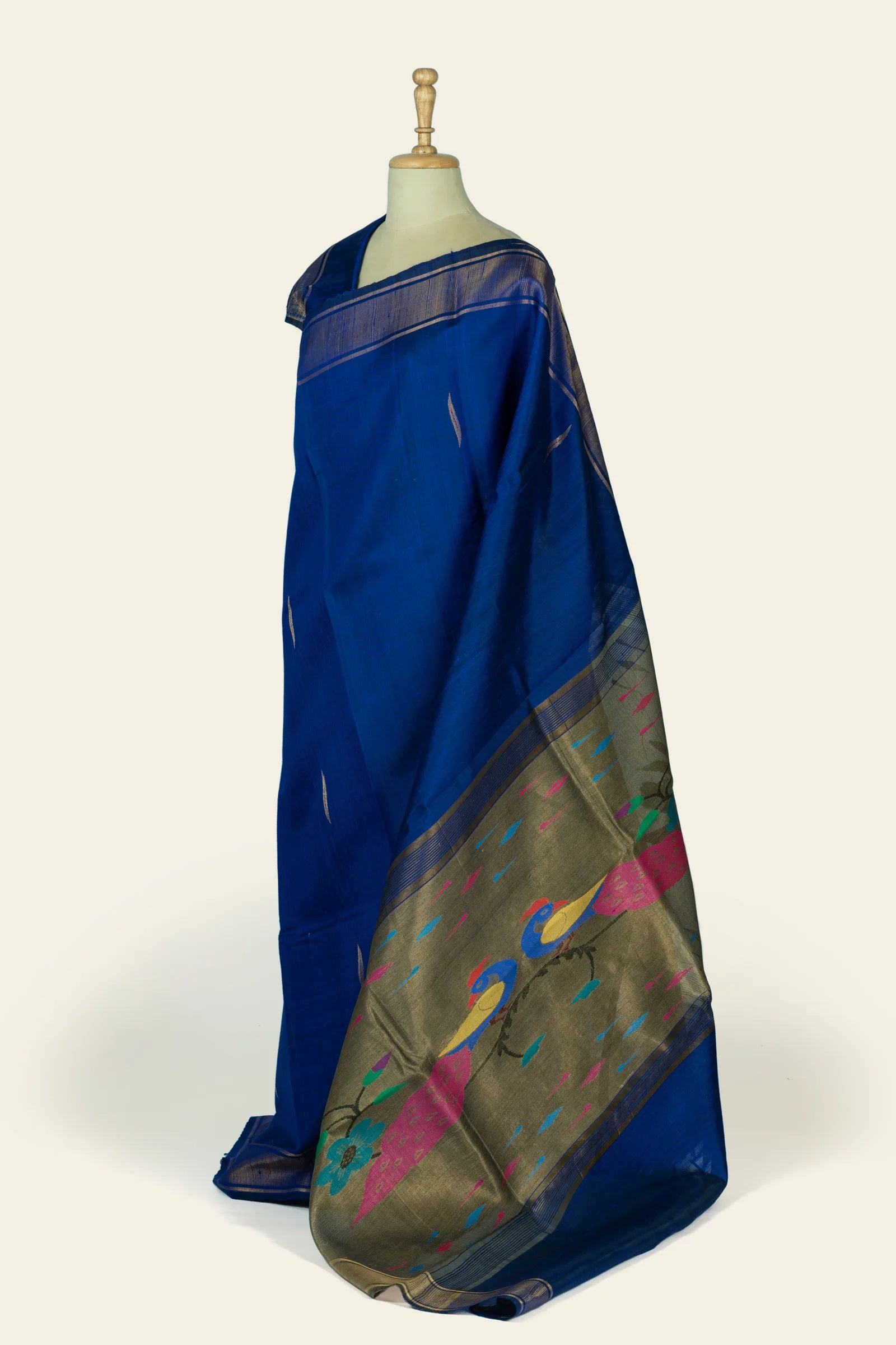 Side view of the saree showing the indigo blue fall and the pallu with an olive-gold woven panel decorated with birds and scattered colour drops.