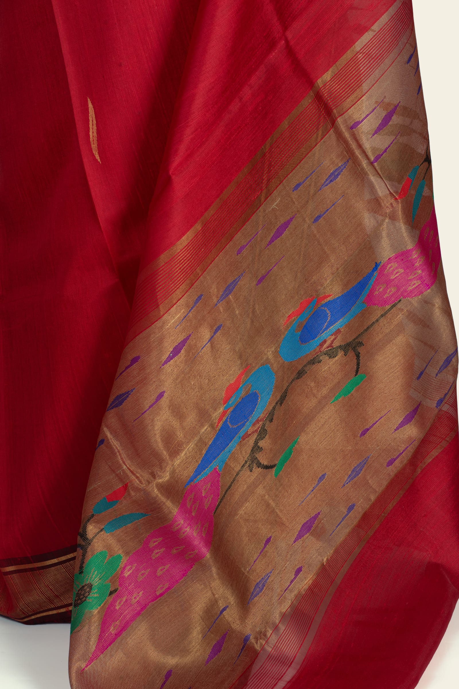 Close-up of the saree pallu showing a gold woven section with blue and pink bird-like motifs and floral shapes.