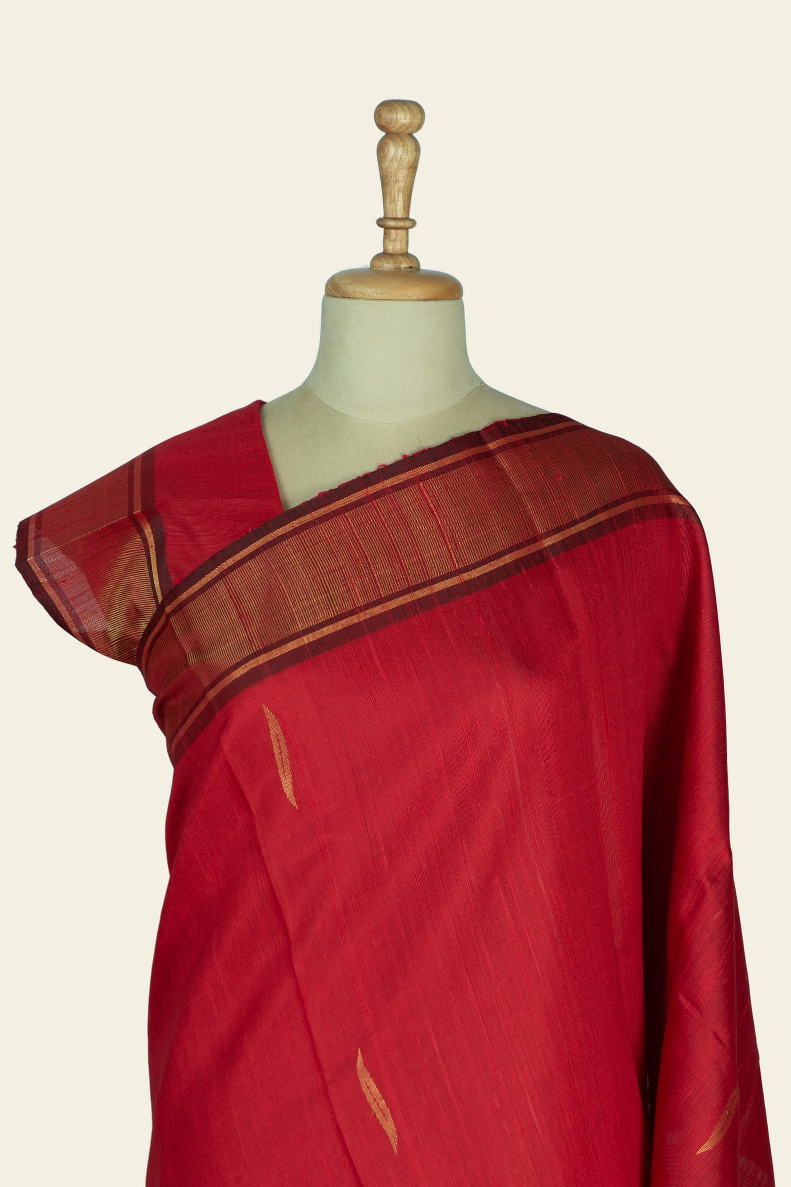Full length view of the saree on a mannequin with the pallu folded to show the patterned gold border and scattered gold motifs on the body.