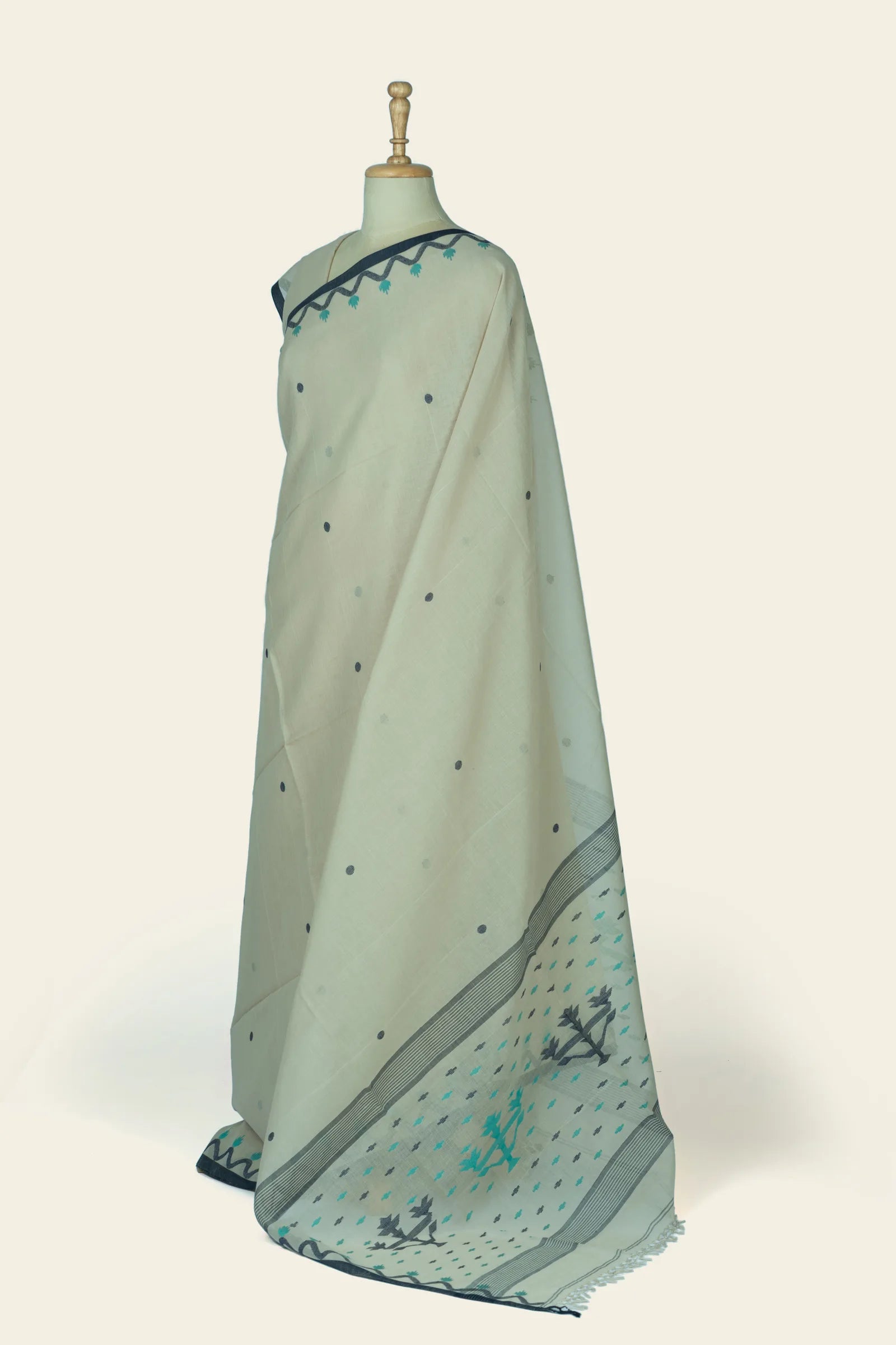 Angled view showing saree drape and pallu with striped border and small geometric motifs in teal and grey.