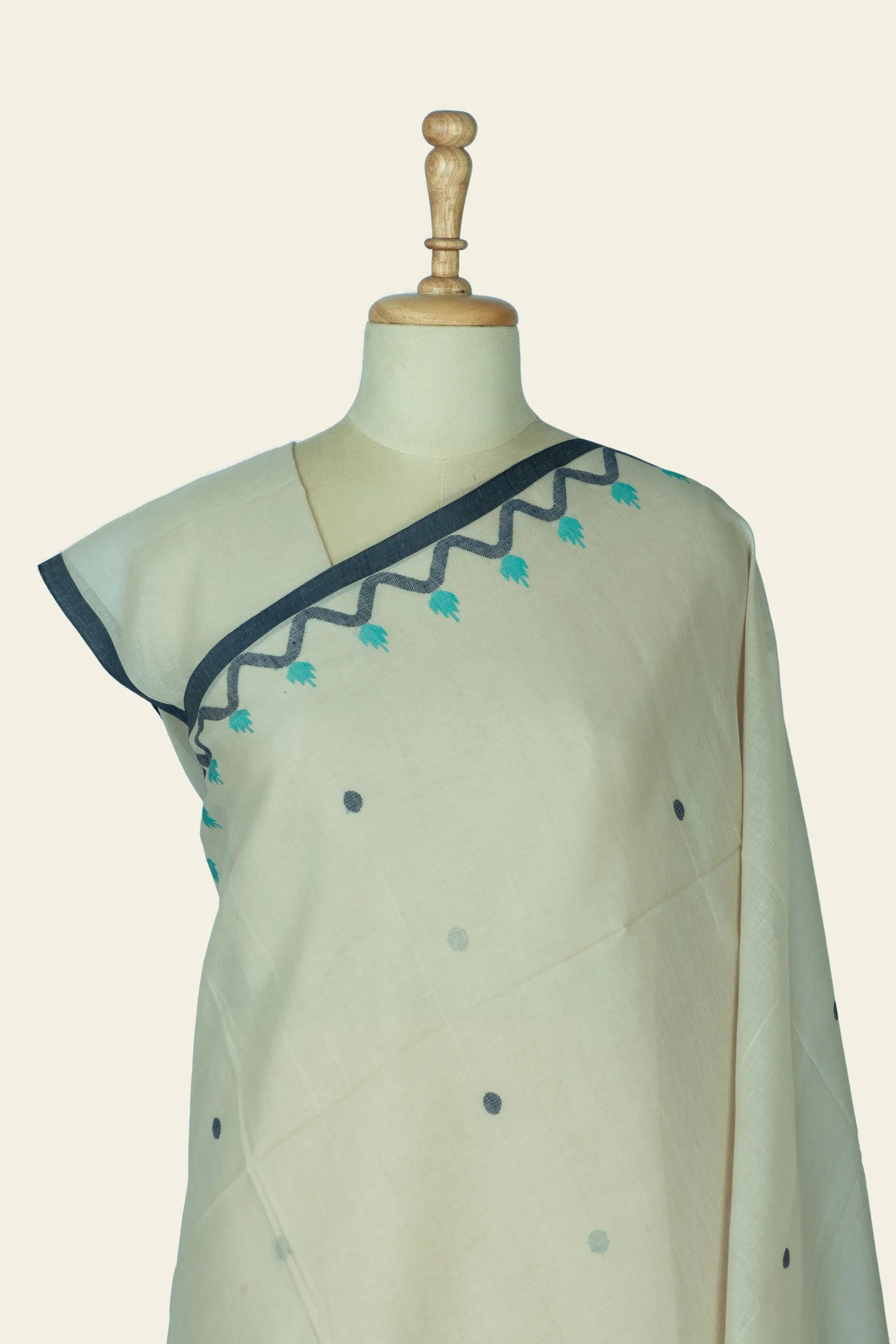 Close upper torso view of the saree showing the blouse-edge and zigzag border with tiny floral drops.