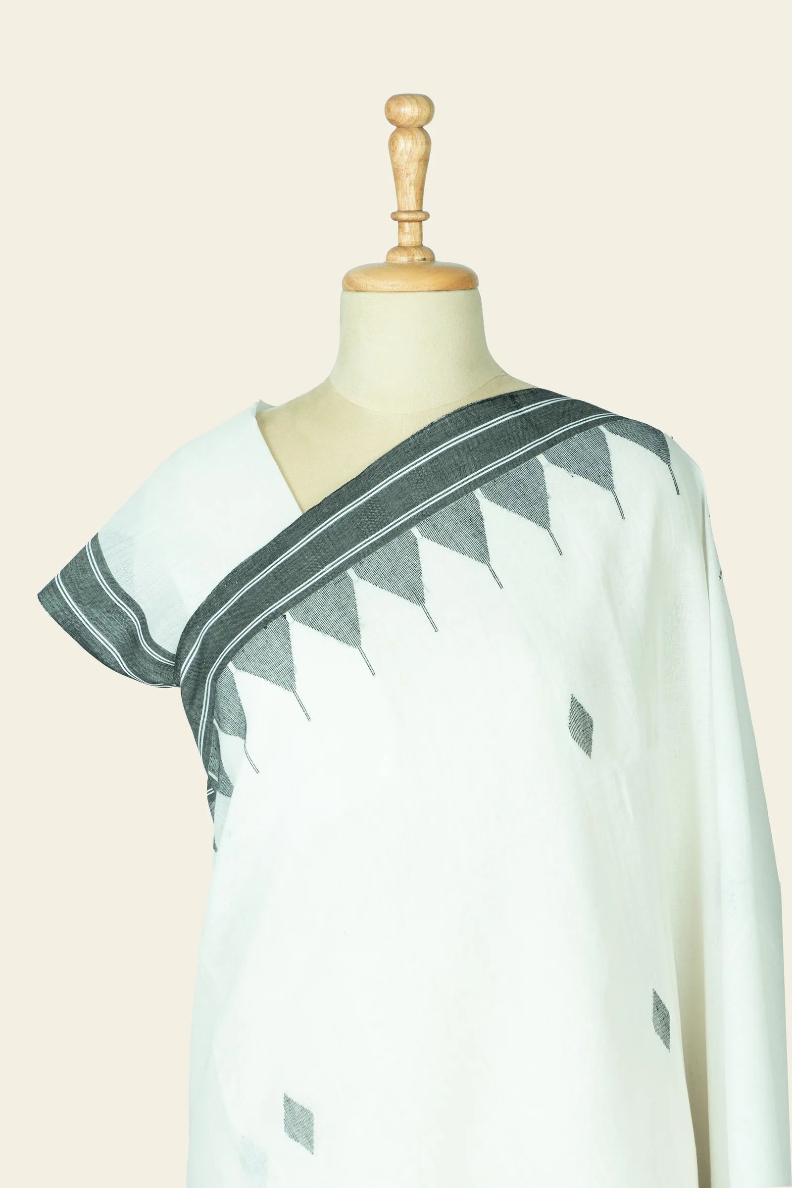 Close-up of the shoulder and blouse area showing the black triangular motif band along the saree border.
