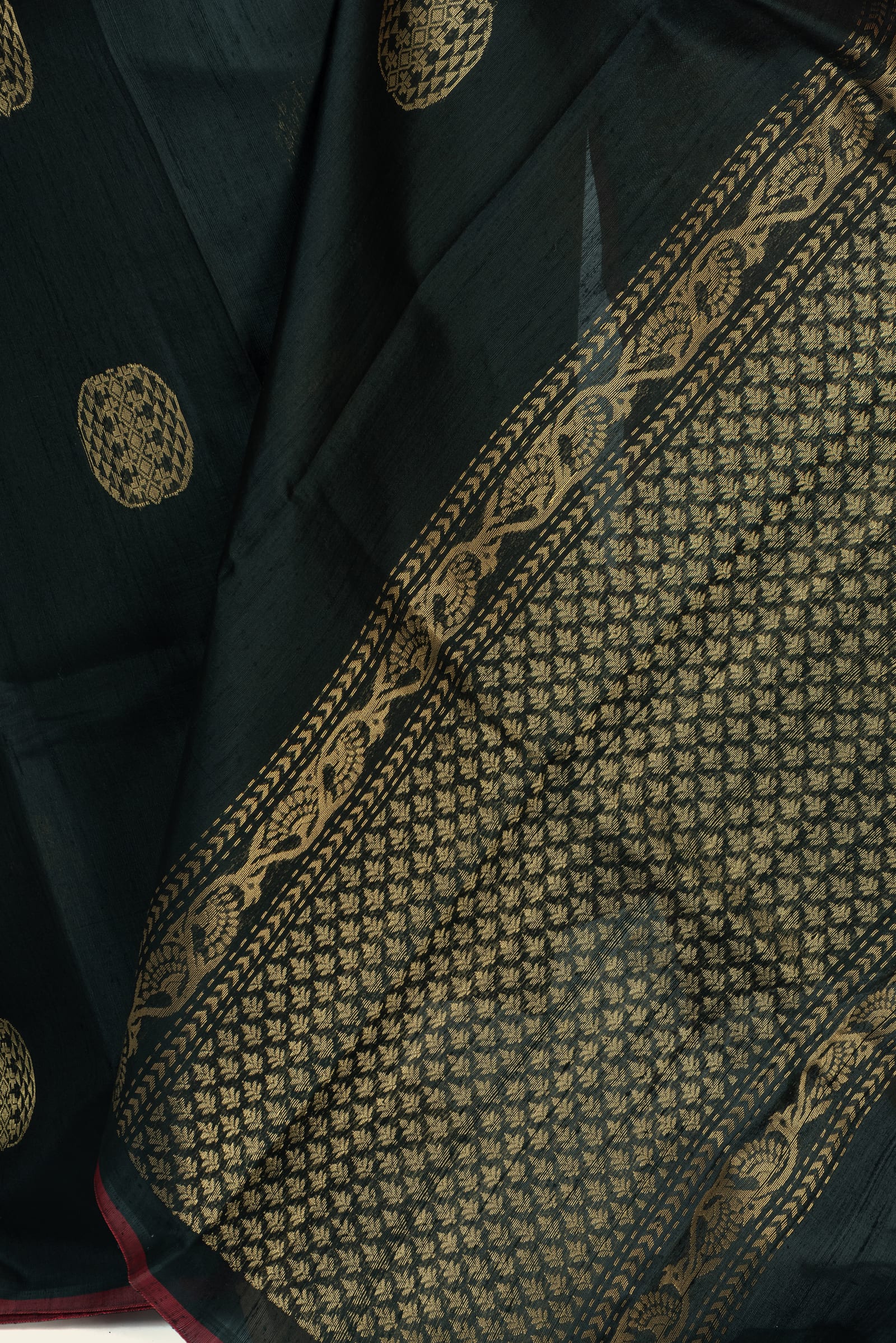 Close-up detail of the saree pallu showing the intricate gold woven border and patterned gold field on the pallu.