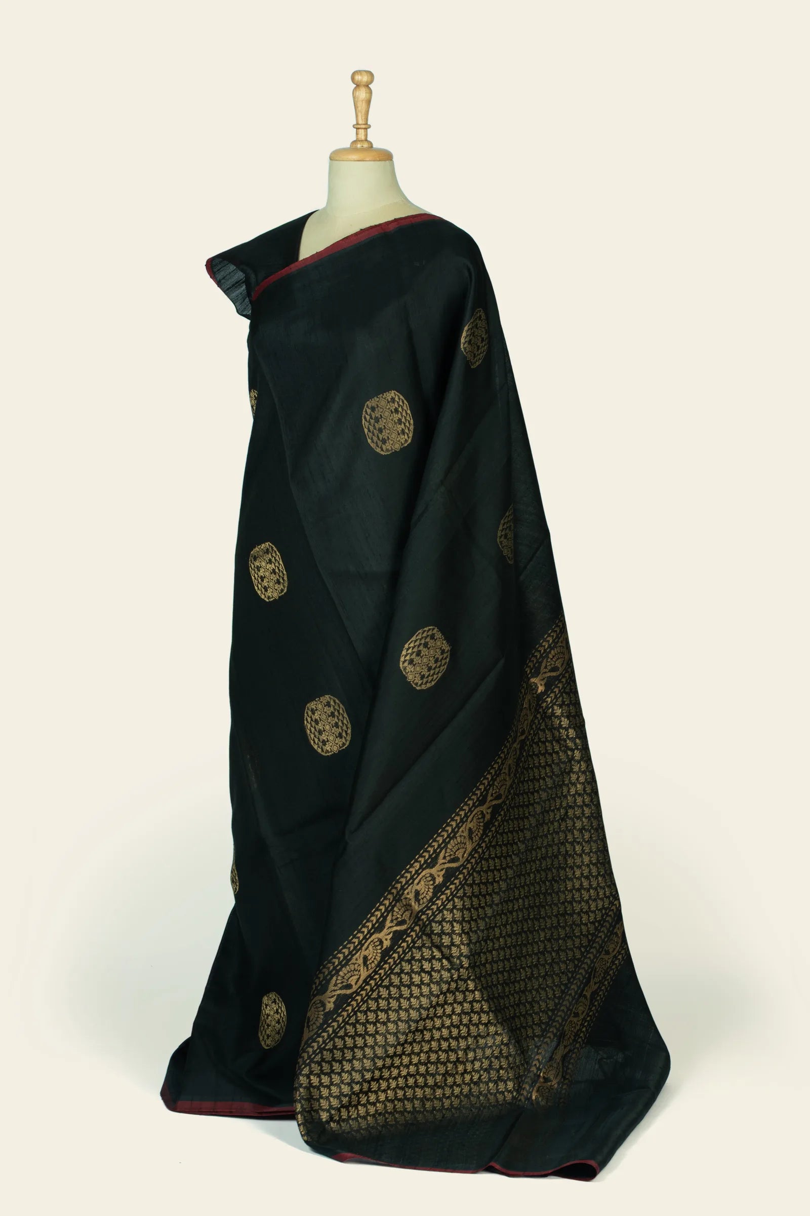 Three-quarter front view highlighting the saree's dense gold woven pallu and border alongside scattered gold butas on the body.