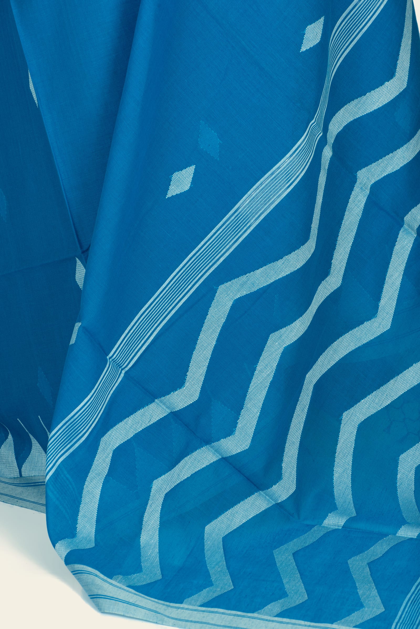 Close-up of the saree border and pallu showing the zigzag border bands and fine woven stripe detail.