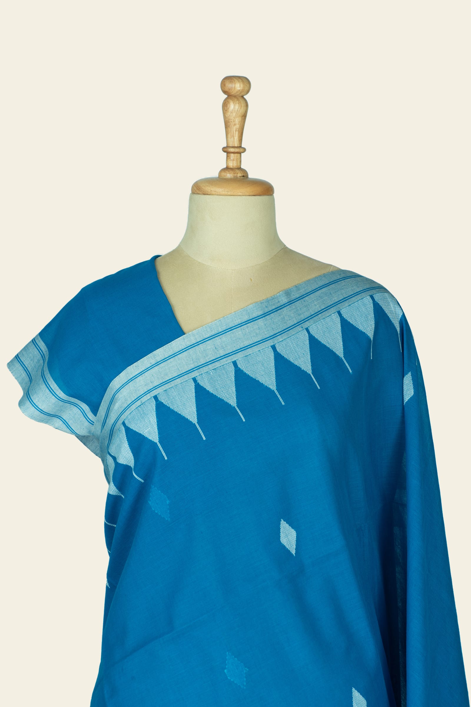Close front view of the blouse and shoulder area showing a woven triangular border and scattered diamond motifs on the saree body.