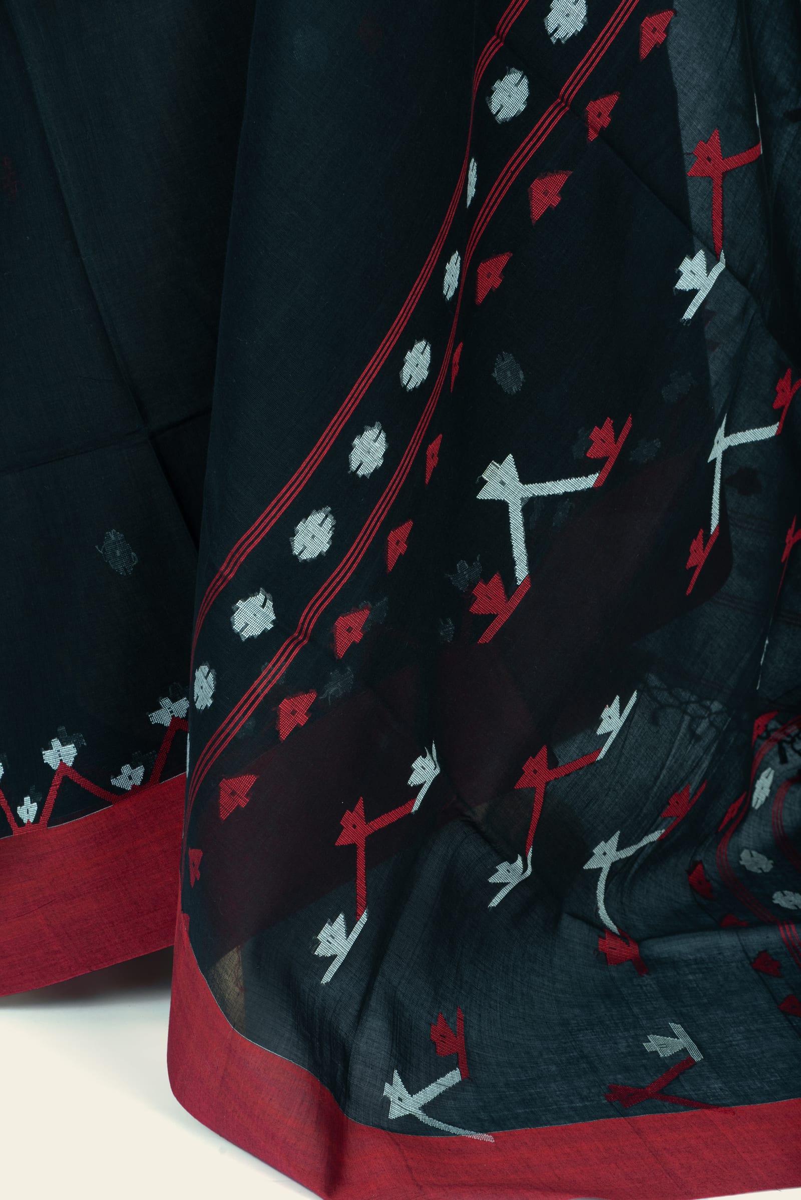 Detailed close-up of the pallu and border showing geometric motifs and woven circular buta.