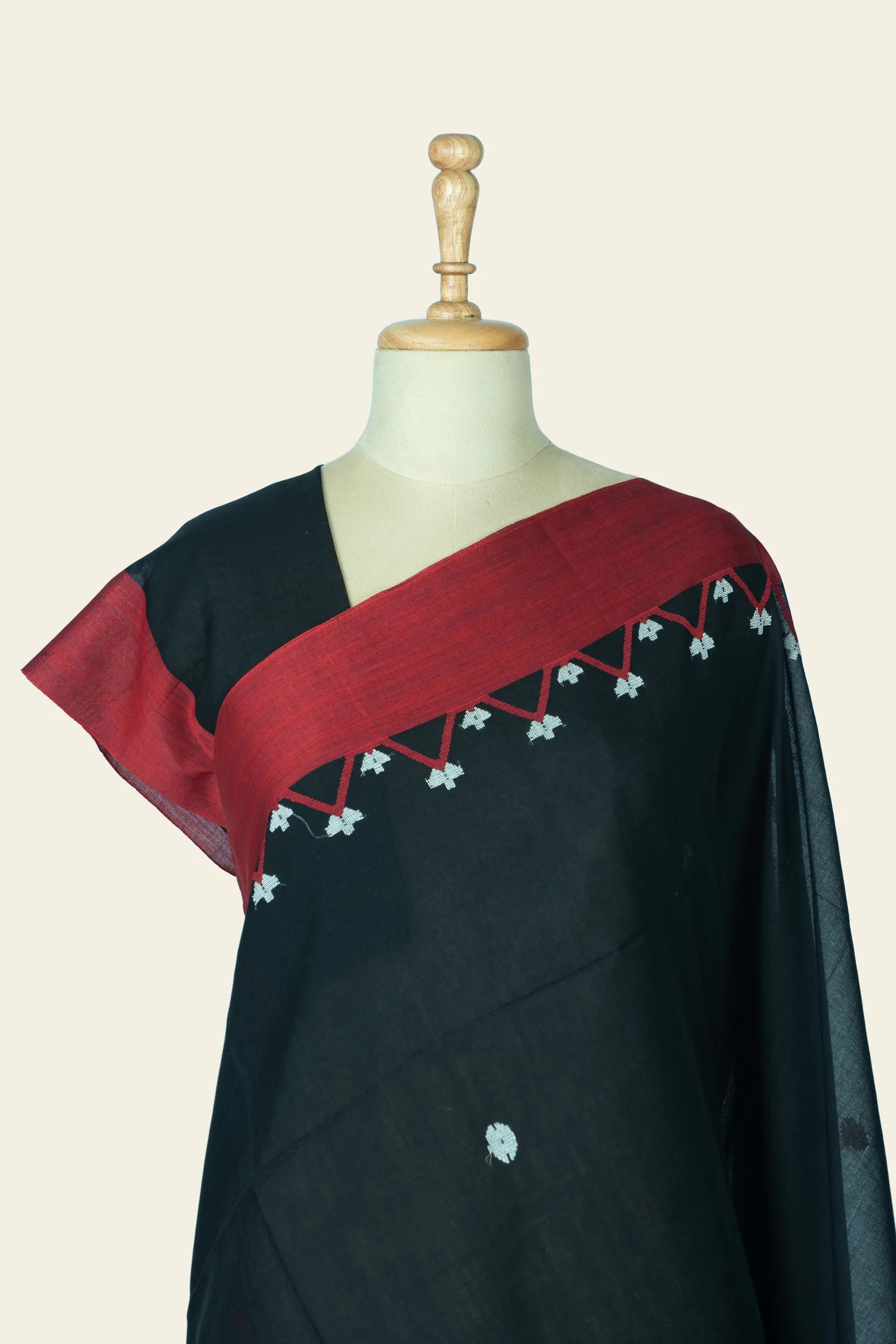 Close-up of the shoulder and neck area showing the maroon border and the triangular motif row with small white motifs.