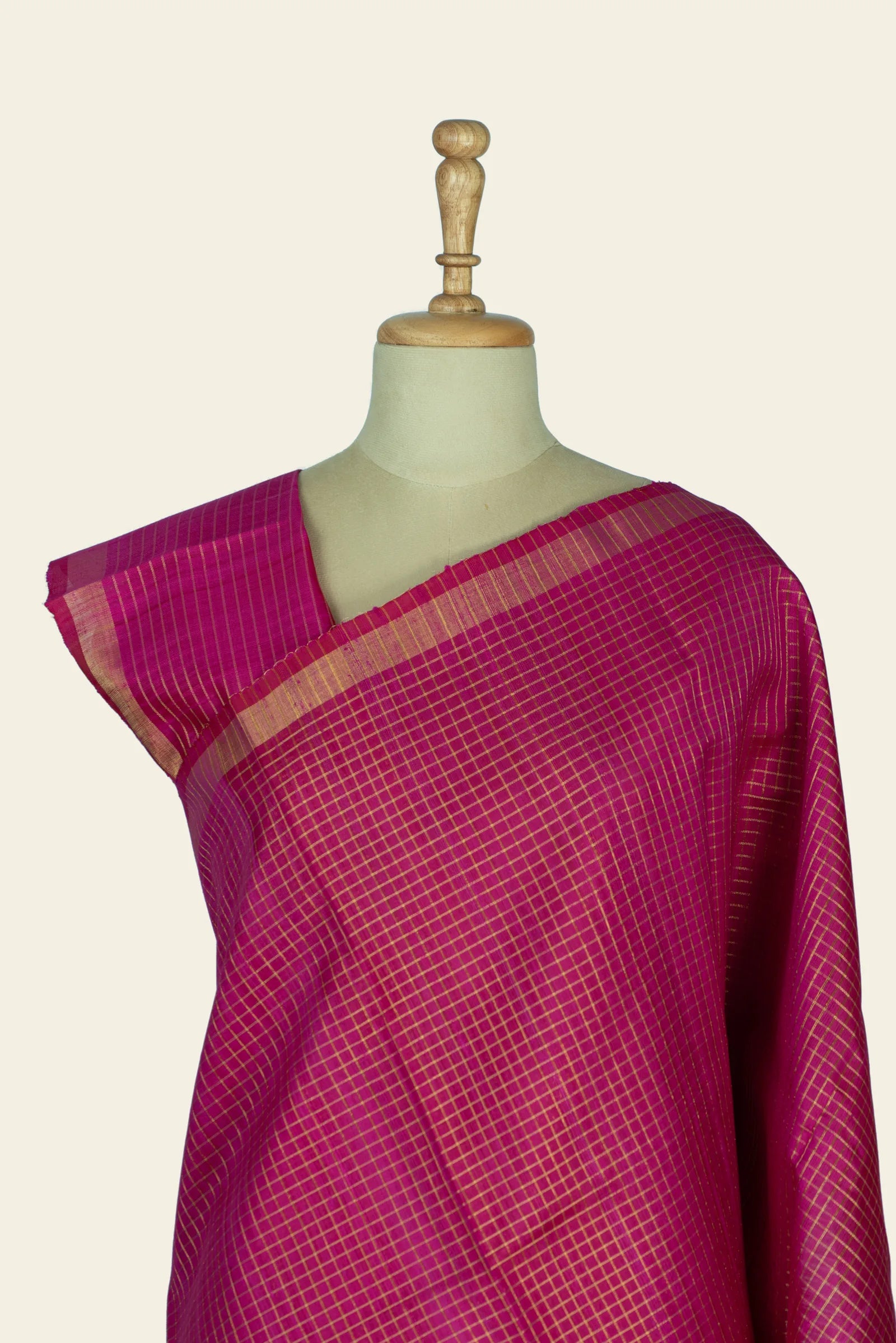Close front view of the blouse area and upper saree showing narrow gold-lined pallu border and dense checked pattern across the chest.