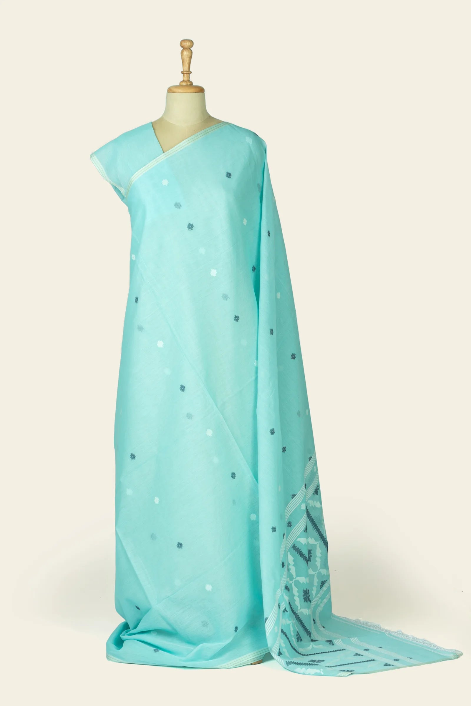 Full-length drape on a mannequin showing a sea blue saree with small scattered buta motifs and the pallu pooled at the hem.