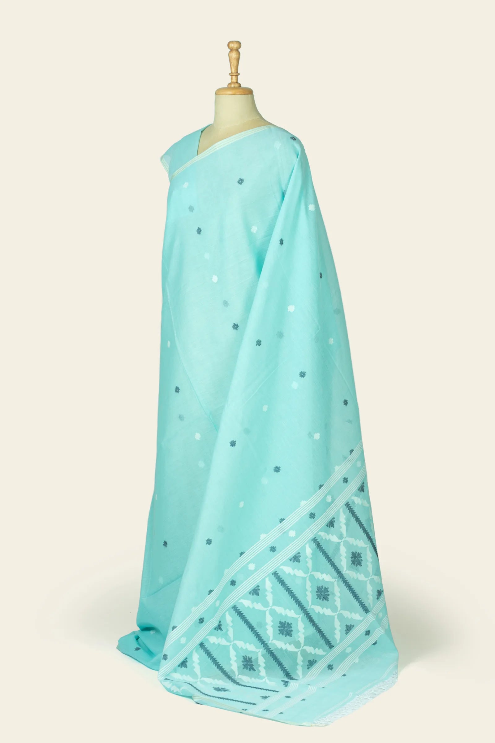 Three-quarter side view of the saree showing scattered motifs across the body and a glimpse of the patterned pallu.
