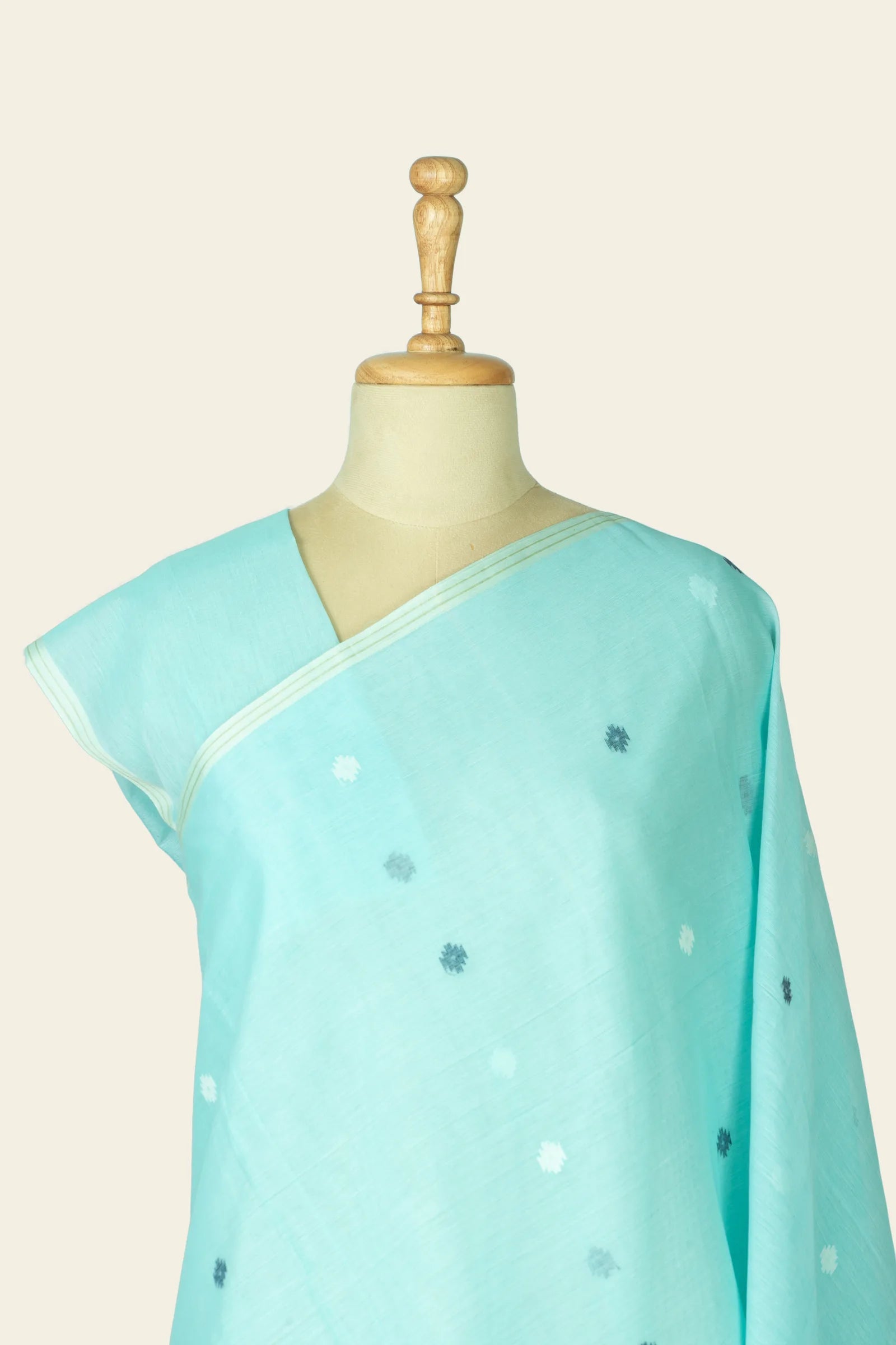 Close crop of the mannequin torso showing the saree pleat at the shoulder and small scattered motifs on the chest area.