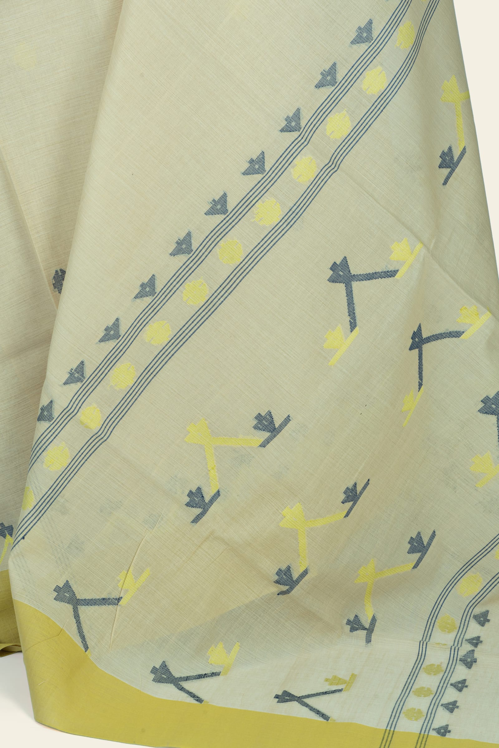 Close-up of the saree's pallu showing woven diagonal band, round motifs and scattered geometric shapes in grey and yellow.